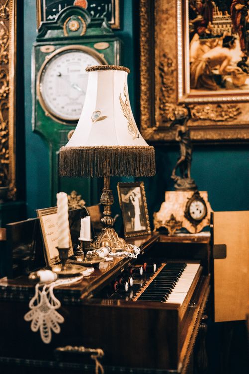 Free Charming vintage interior featuring an antique piano with ornate lamp and artwork. Stock Photo