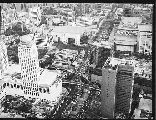 Free Monochrome aerial view of a bustling cityscape featuring skyscrapers and busy streets. Stock Photo