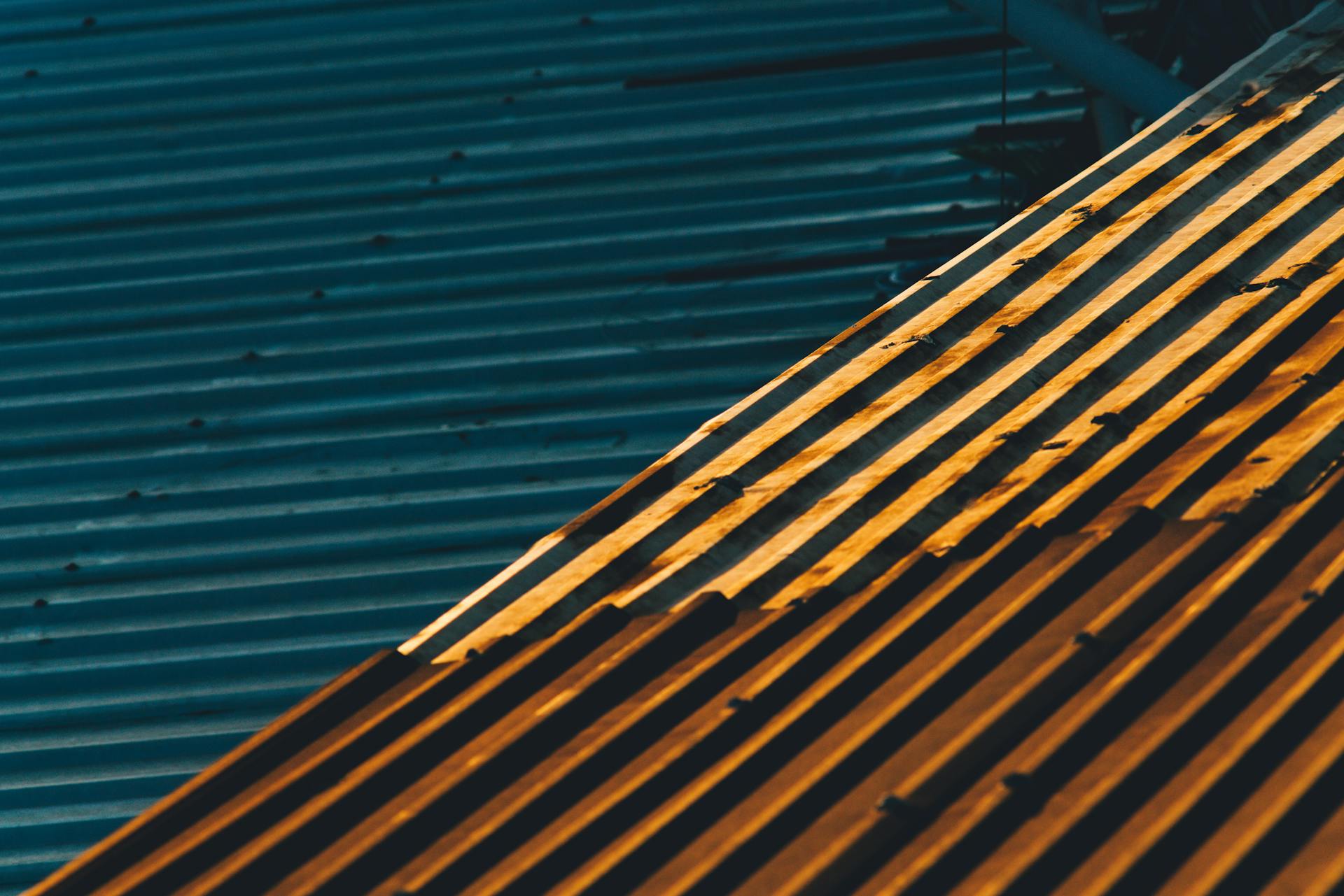 Close-up of corrugated metal sheets with sunlight creating striking patterns.
