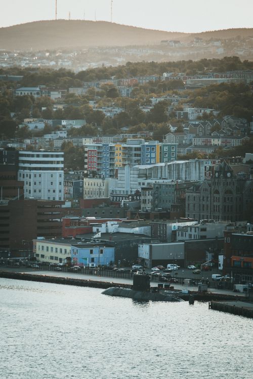 Free A vibrant aerial cityscape featuring colorful buildings along a waterfront, captured at dusk. Stock Photo