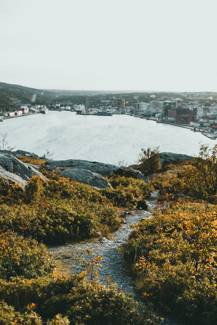 Mountain Trail Leading Towards City On Lake Shore