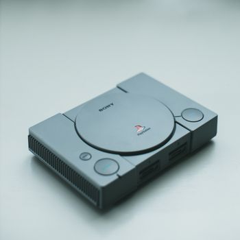 Minimally styled image of a Sony PlayStation console on a sleek white surface.