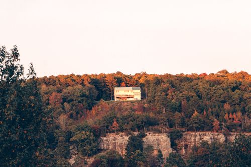 Free A secluded house sits atop a cliff surrounded by vibrant autumn foliage in Arkansas. Stock Photo