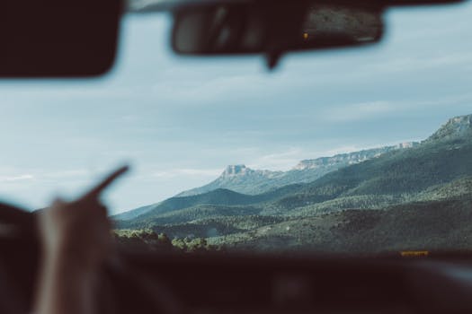 Beautiful view of mountain ranges in Colorado seen through a car windshield, highlighting travel adventure.
