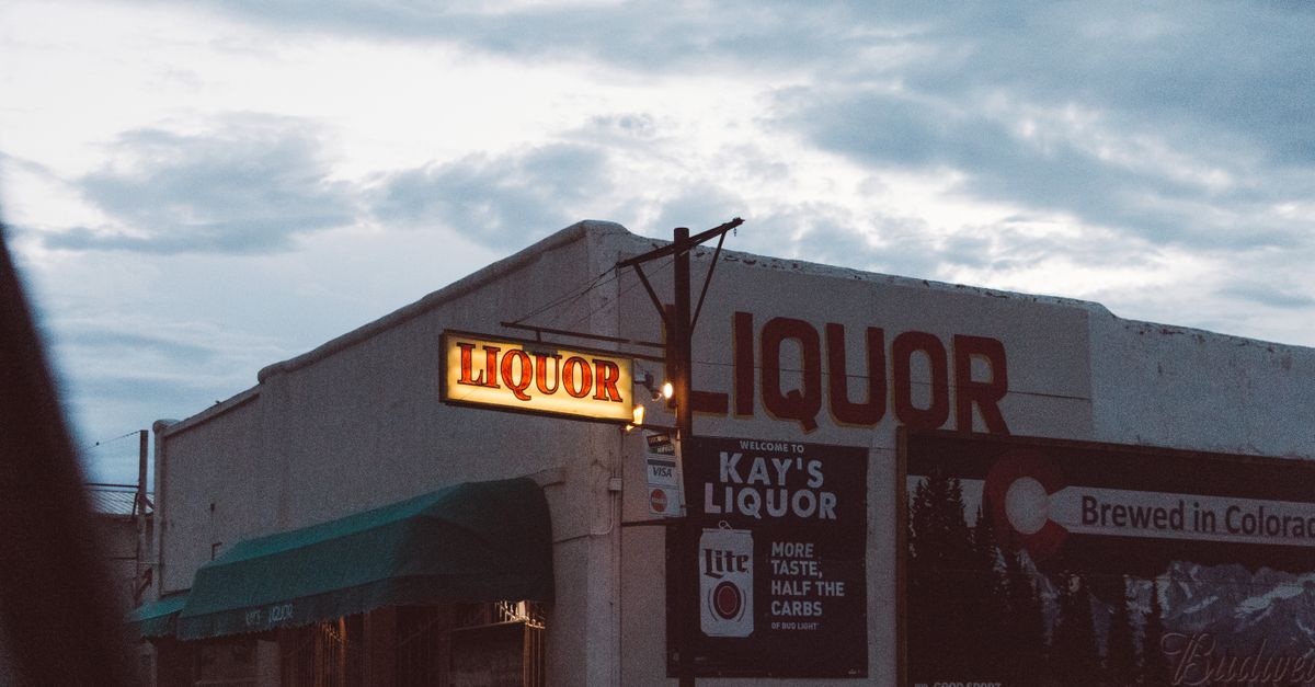 Captivating image of an old liquor store with a vintage sign at twilight in Colorado.