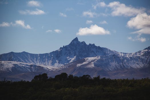 Stunning snow-capped mountain peaks with a vibrant blue sky backdrop, perfect for nature enthusiasts.