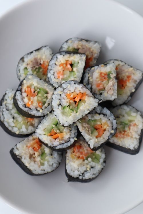Free Top view of delicious sushi rolls with rice salmon and cucumber served on white ceramic plate Stock Photo