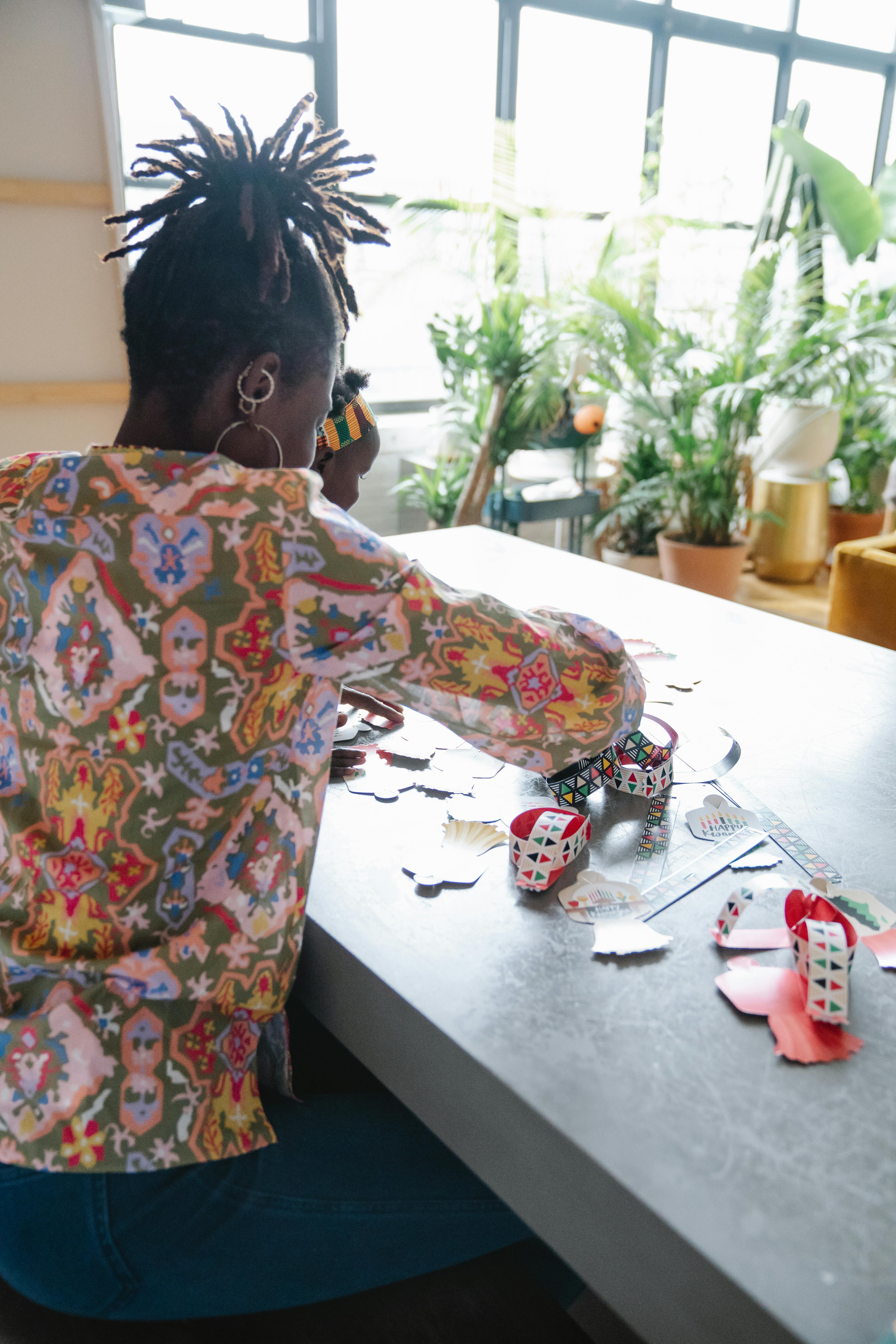 Woman engaging in arts and crafts with vibrant materials on a table indoors.