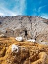 Person with Arms Wide Open Standing Near the Rock Mountains