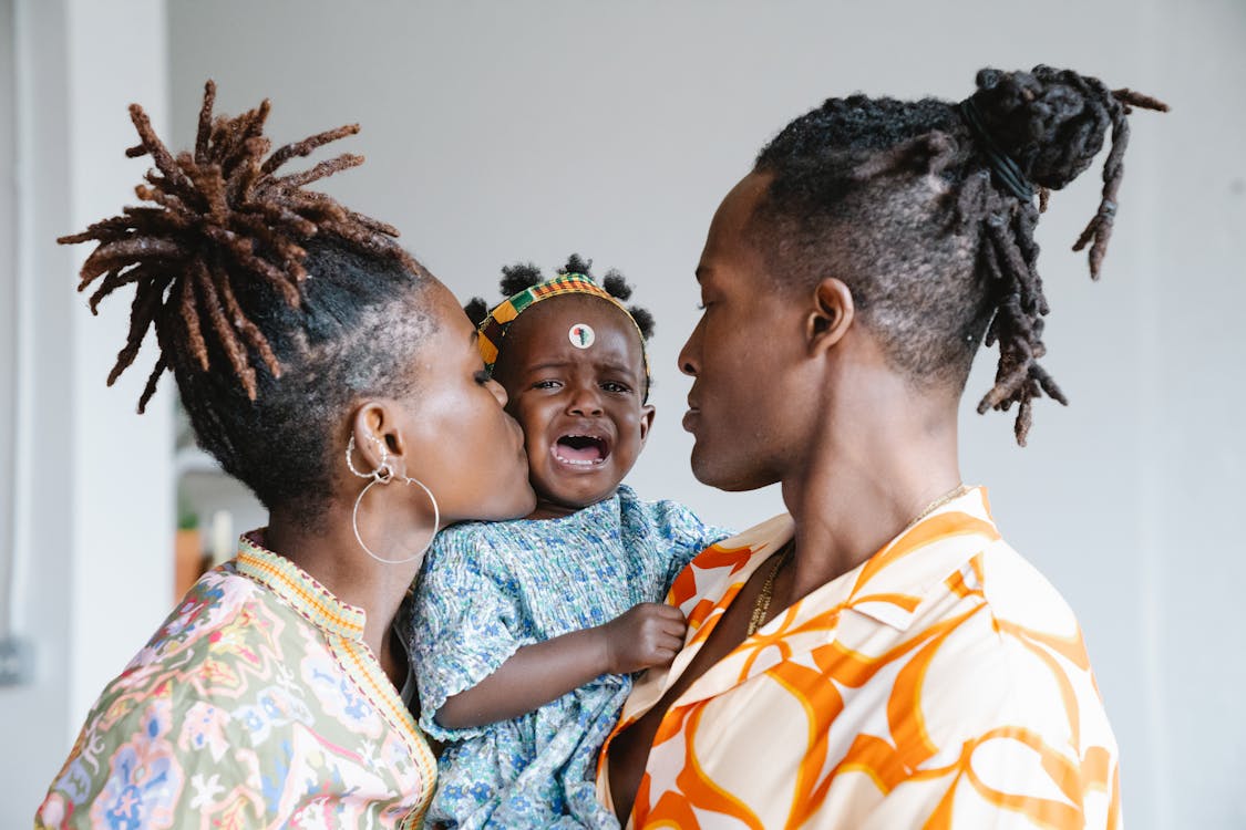 Mom Kissing Her Cute Crying Daughter