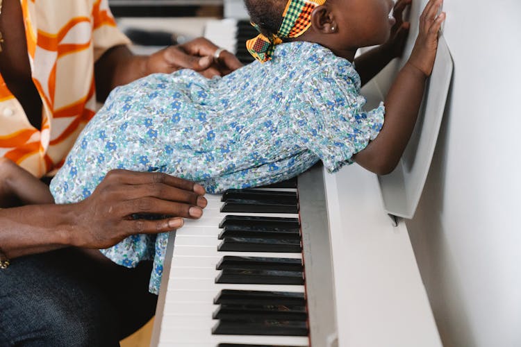 Child Laying On A Piano