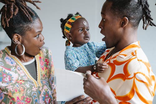 Free Couple Looking at Their Cute Daughter Stock Photo