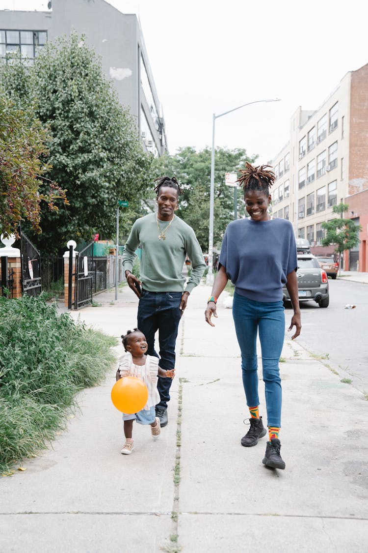 Couple Walking With Their Daughter Outside