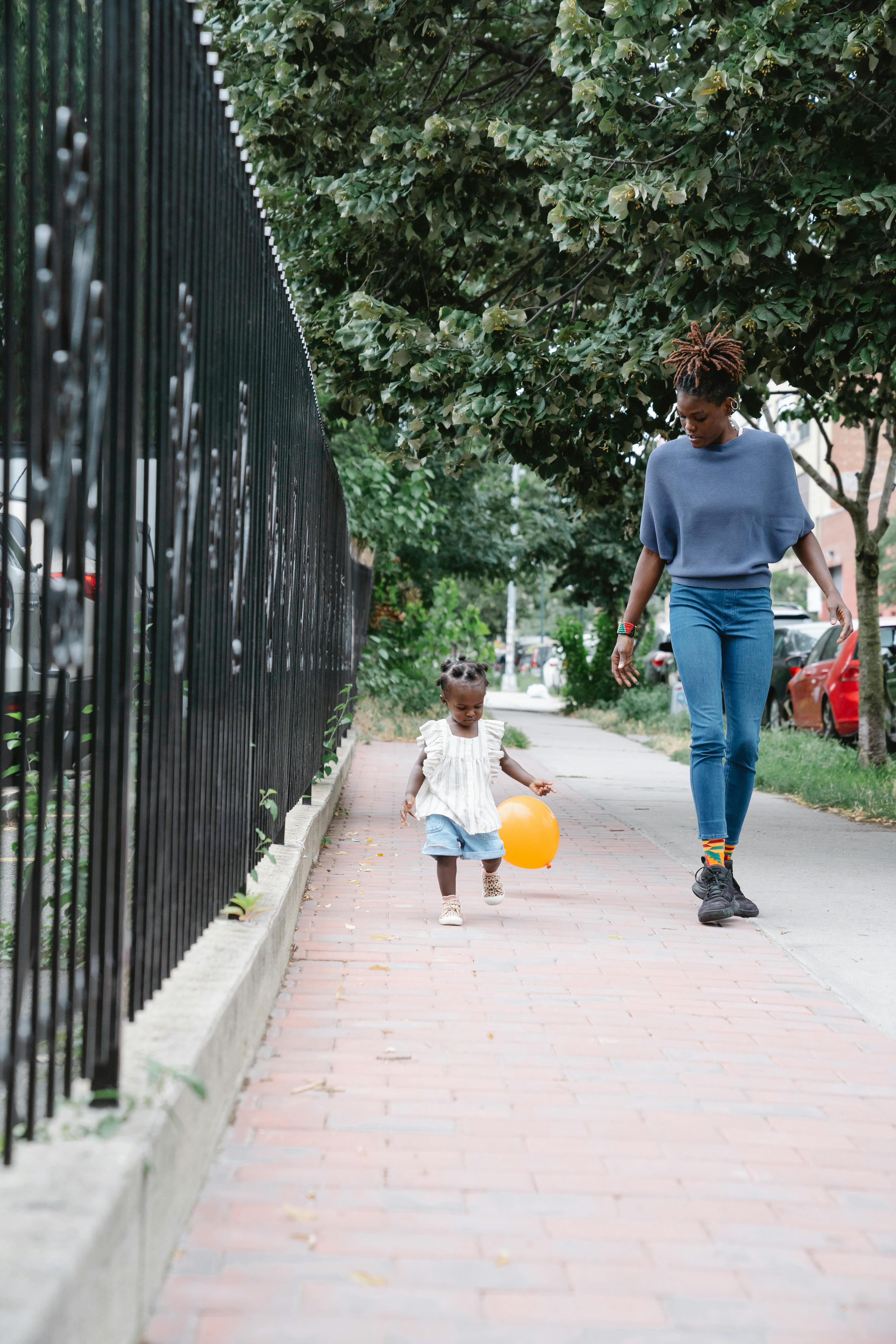 mother and daughter walking at a sidewalk