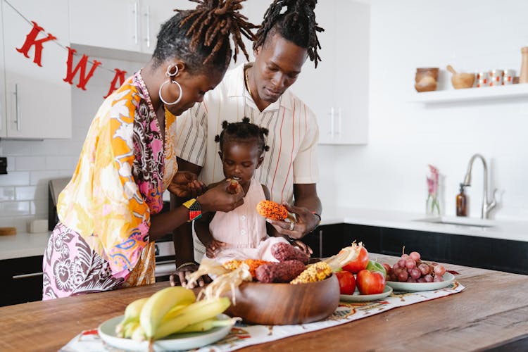 Mom And Dad Feeding Their Daughter