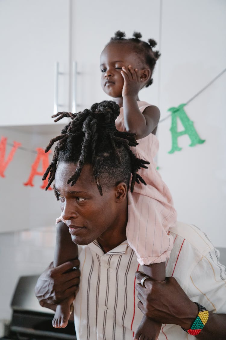 Dad Carrying His Daughter On His Shoulders