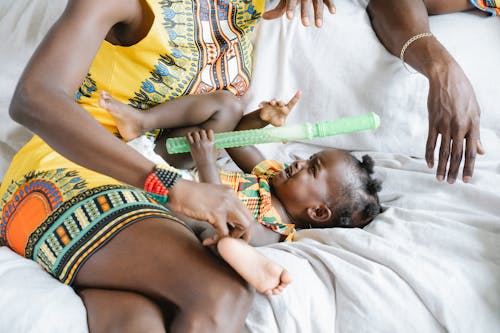 A Crying Baby Girl Lying Down next to Her Mother