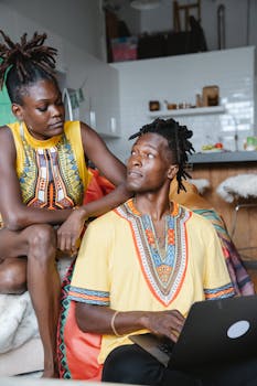 A couple in traditional clothing engages in a warm conversation at home.