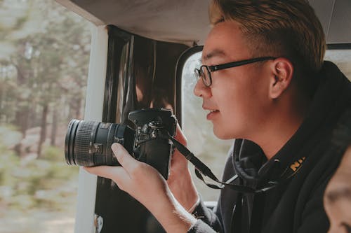 Foto Pria Yang Memegang Kamera Dslr Nikon