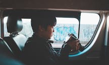 一名年轻人在车内用单反相机拍摄城市涂鸦