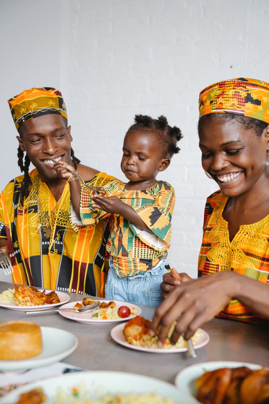 African family wearing vibrant traditional clothing enjoying a meal together in America