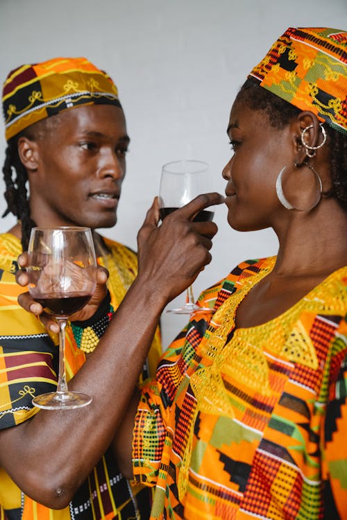 Couple in Traditional Clothes Drinking Red Wine Together