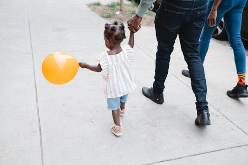 A Family Walking on Sidewalk