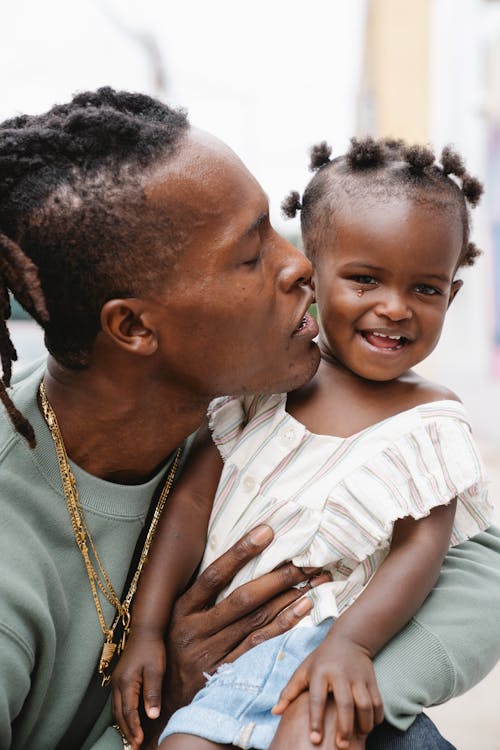 A Dad Kissing Her Cute Daughter