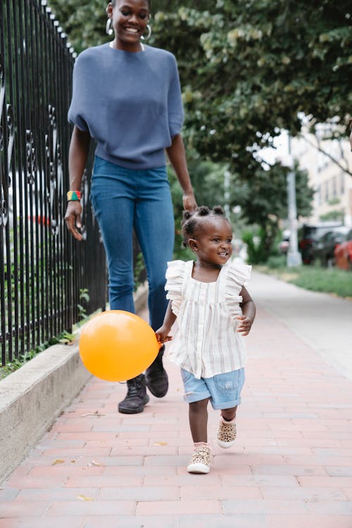 Mother and Daughter Walking at a Sidewalk