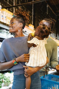 A joyful family enjoying grocery shopping with their young daughter in a supermarket.