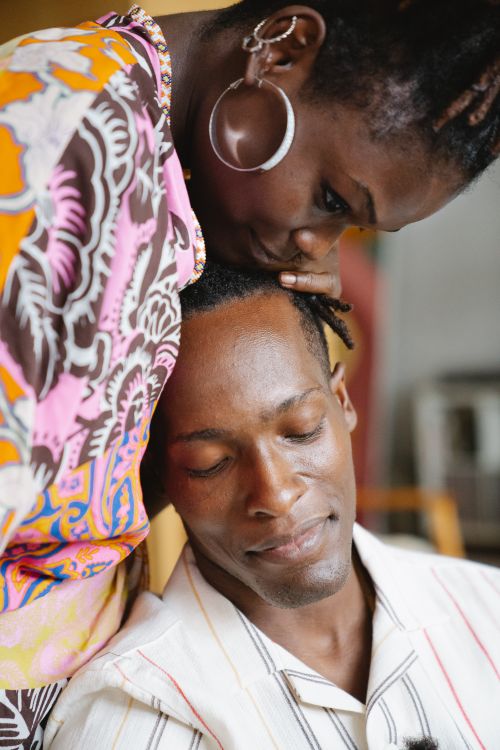 Free A tender moment of affection between a couple, expressing love and intimacy in an indoor setting. Stock Photo