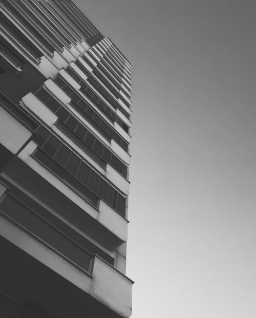 Free Dramatic grayscale low angle shot of a high-rise building facade emphasizing architectural design. Stock Photo