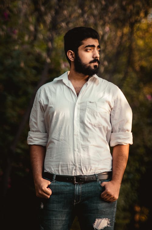 A Bearded Man in White Shirt while Looking Over Shoulder