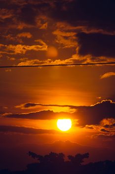 Captivating sunset with dramatic clouds and silhouette, showcasing the golden hour's vibrant hues.