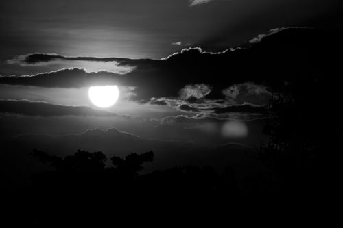 Free Black and white sunset with silhouettes and dramatic clouds, capturing a serene evening scene. Stock Photo