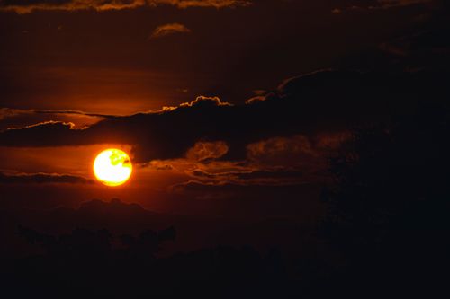 Free A stunning sunset with dramatic clouds and a silhouette in the foreground. Stock Photo