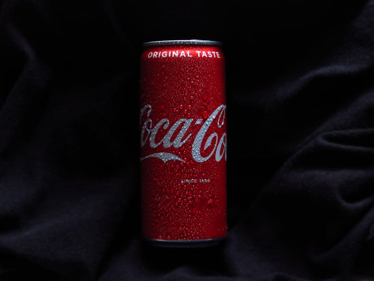 Close-Up Photo Of A Coca Cola Can On A Black Textile