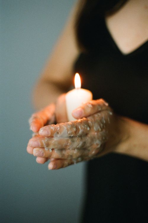 Free Close-up of wax-covered hands holding a lit candle, conveying warmth and tranquility. Stock Photo