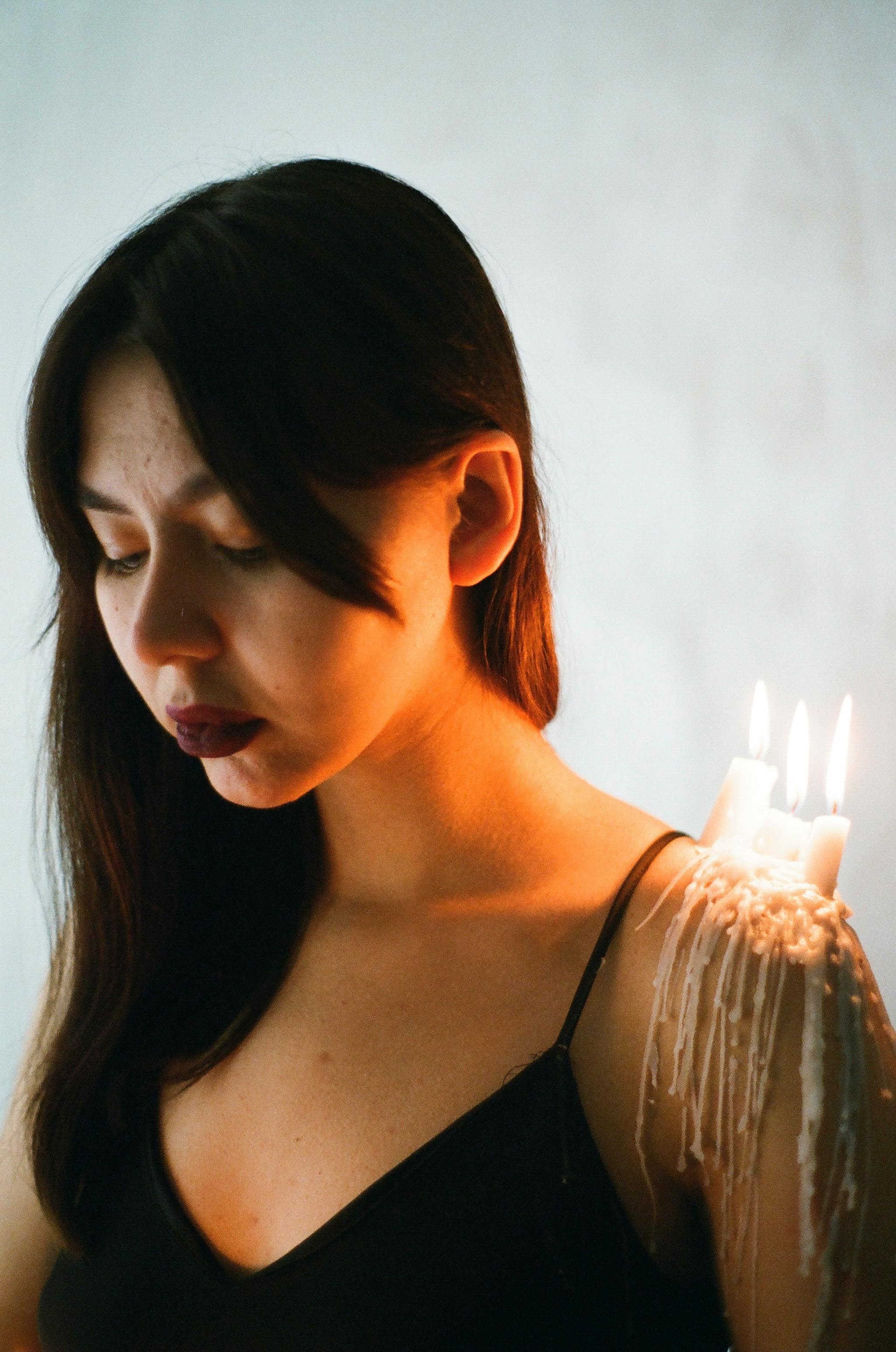 portrait of young woman with candles on shoulder