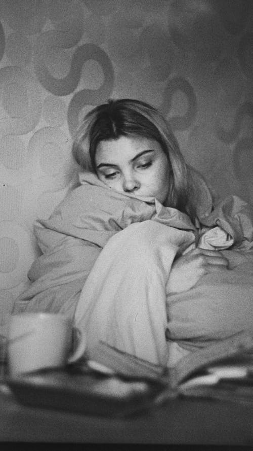 Monochrome Photo of a Woman with a Comforter