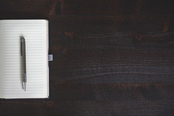 Open notebook and pen on a dark wooden desk — photo by Negative Space on Pexels