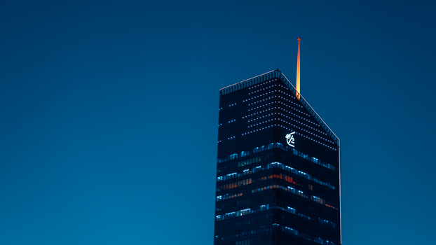 A striking skyscraper in Lyon, France, illuminated against a clear evening sky.