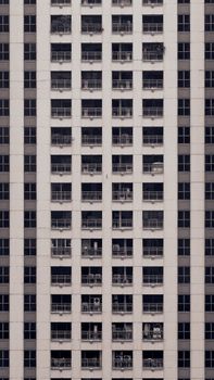 Vertical shot of a concrete high-rise apartment facade showcasing architectural symmetry