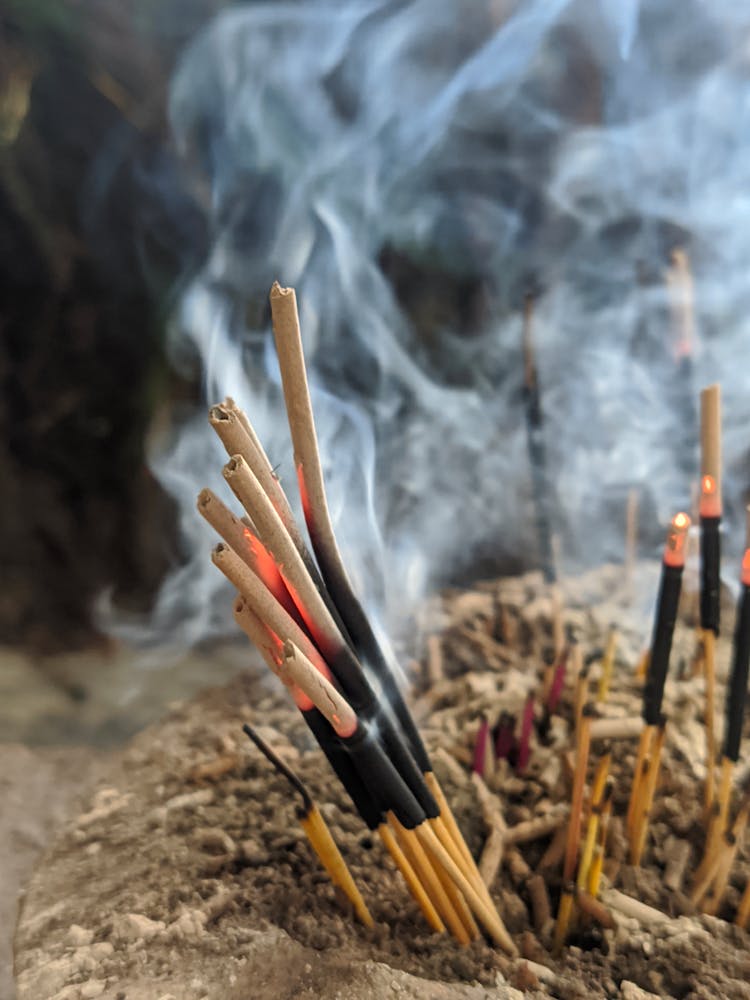 Burning Incense Stick On Brown Soil 