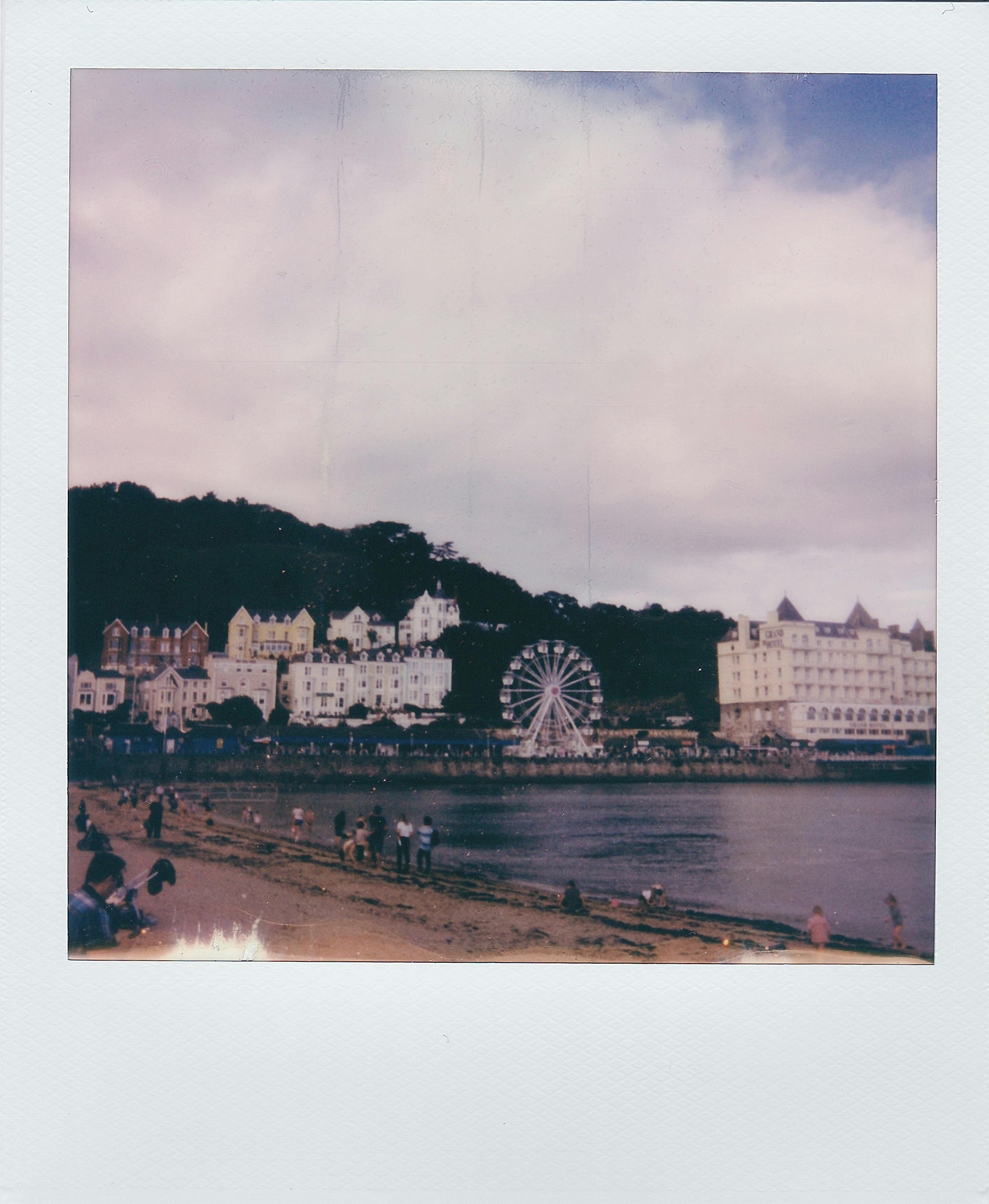 Charming seaside view of Llandudno with the Ferris wheel and colorful buildings.
