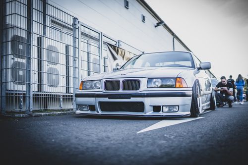 Free A luxury modified car with lowered suspension showcased in an urban environment. Stock Photo