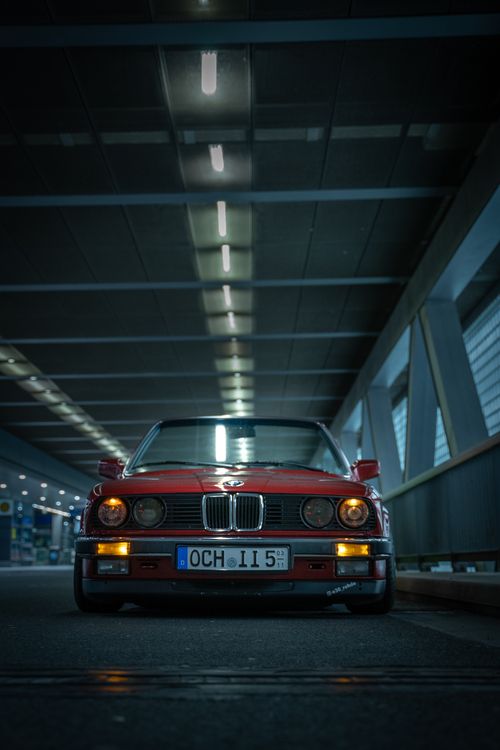 Free Vintage red car captured indoors at night with dramatic lighting and low angle. Stock Photo