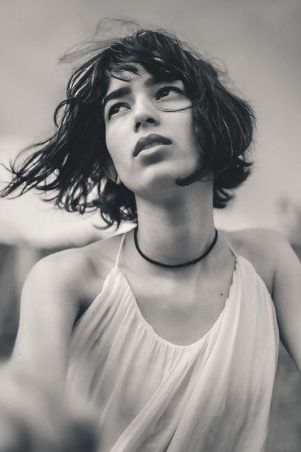 Striking black and white portrait of a woman with short hair and a thoughtful expression.