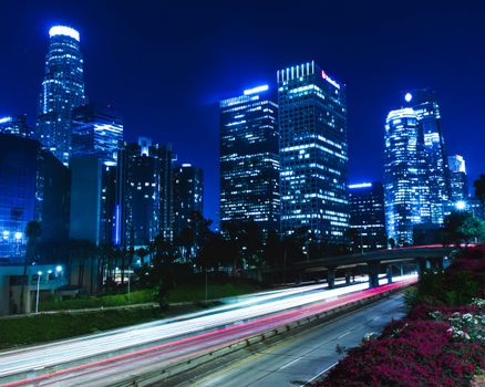 Vibrant cityscape of Los Angeles downtown with light trails at night.