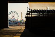 A captivating view of a ferris wheel and fairground rides seen through a silhouette at sunset in Boise, Idaho.